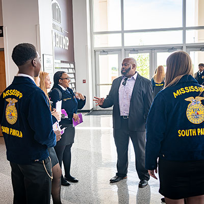 Josh Davenport instructs students wearing blue FFA jackets with Missisippi South Panola on the back